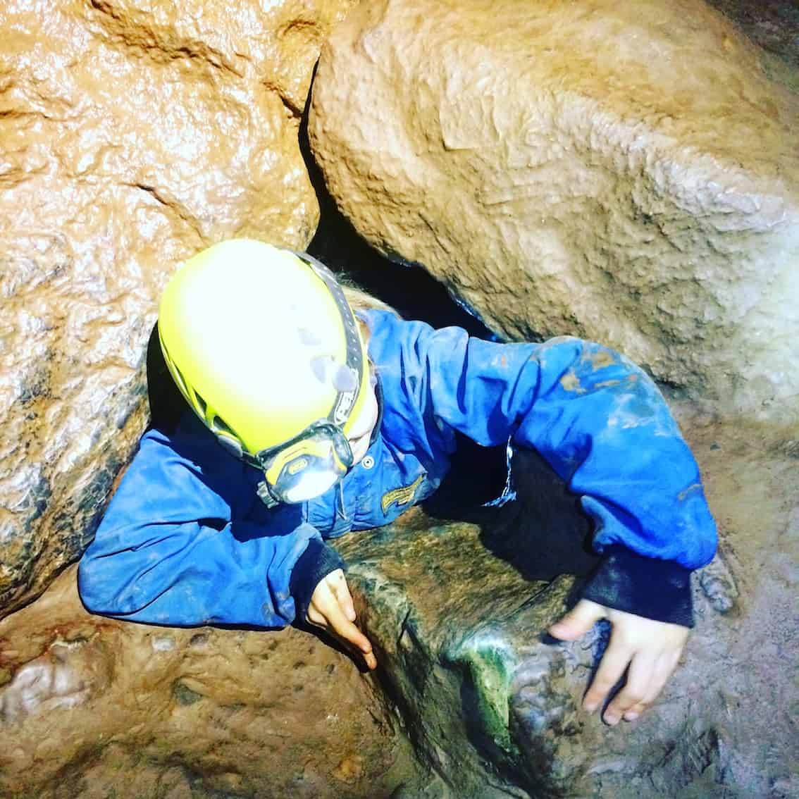 caving in devon - climbing through a small hole